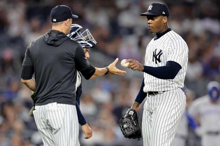 Aug 19, 2022; Bronx, New York, USA; New York Yankees relief pitcher Aroldis Chapman (54) hands the ball to manager Aaron Boone (17) after being taken out of the game against the Toronto Blue Jays during the ninth inning at Yankee Stadium.